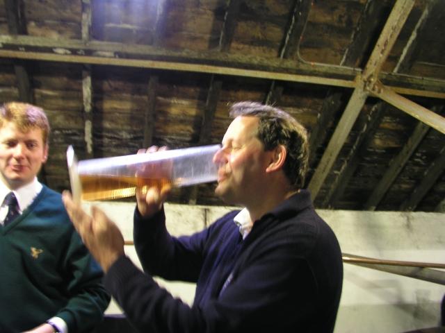 Besucher mit gefülltem Erlenmeyerkolben auf dem Solera-Fass bei Glenfiddich